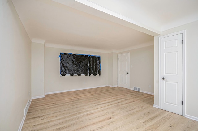 unfurnished room featuring light wood-style flooring, baseboards, and visible vents