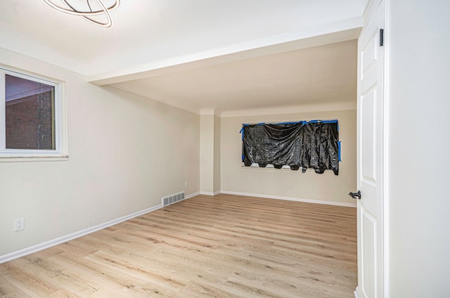 spare room featuring visible vents, baseboards, and light wood-style flooring