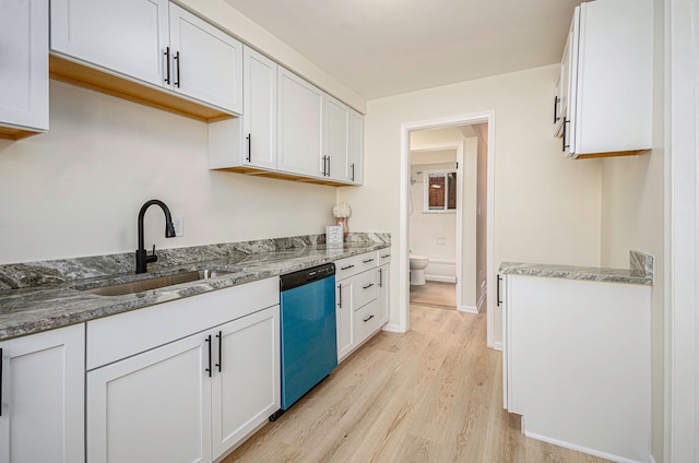 kitchen featuring light stone countertops, dishwashing machine, light wood-style floors, white cabinets, and a sink