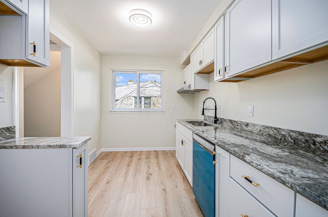 kitchen with dishwashing machine, light stone counters, baseboards, light wood finished floors, and a sink