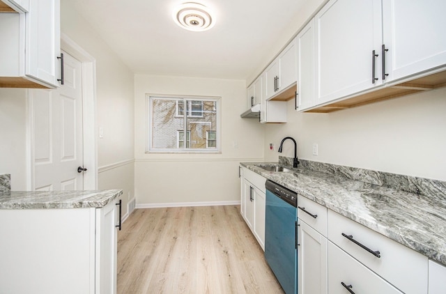 kitchen with dishwashing machine, light stone countertops, light wood finished floors, a sink, and white cabinetry