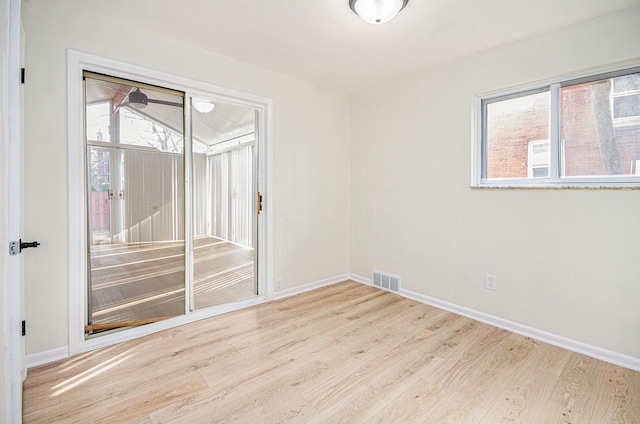 empty room with visible vents, baseboards, and wood finished floors