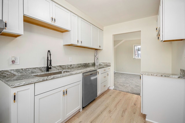 kitchen with light stone countertops, light wood-type flooring, stainless steel dishwasher, white cabinetry, and a sink