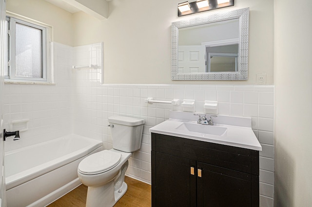 full bathroom with toilet, wood finished floors, tile walls, wainscoting, and vanity