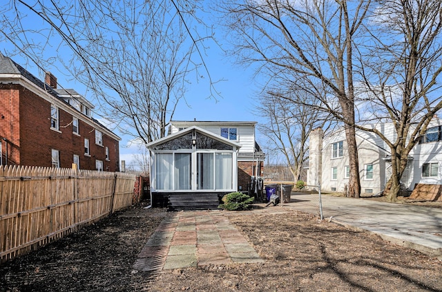 back of property with an outdoor structure, fence, and brick siding