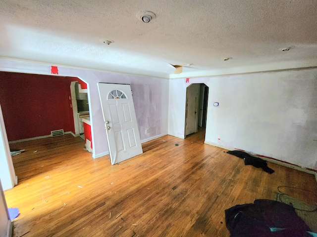 20048 Fleming St, Detroit, MI 48234 - spare room featuring visible vents, wood finished floors, arched walkways, and a textured ceiling