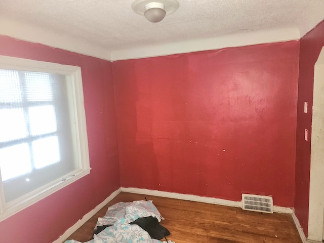 20048 Fleming St, Detroit, MI 48234 - empty room with wood finished floors, a textured ceiling, baseboards, and visible vents