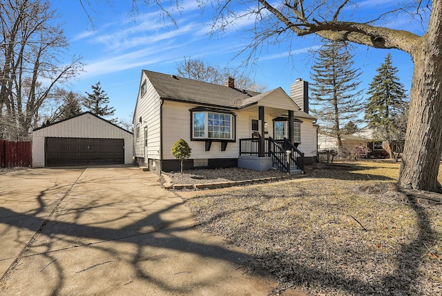 view of front of house featuring a garage, an outbuilding, roof with shingles, and a chimney