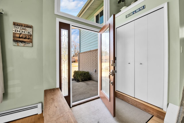 entryway featuring a baseboard heating unit and light wood finished floors