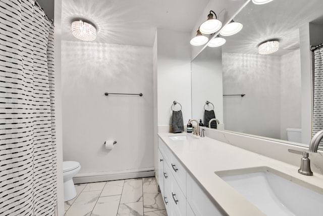 bathroom featuring toilet, marble finish floor, and a sink