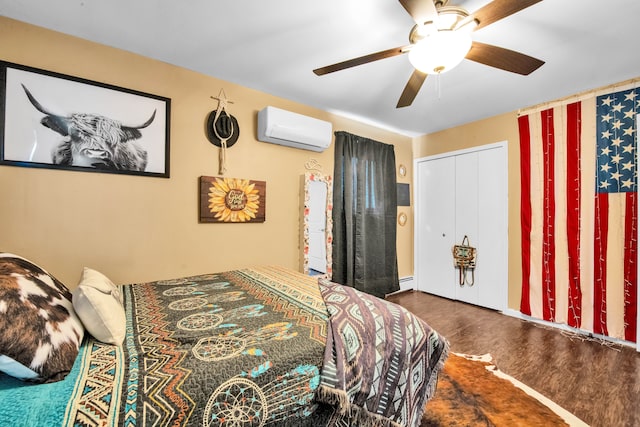 bedroom with ceiling fan, a baseboard radiator, a wall unit AC, and wood finished floors