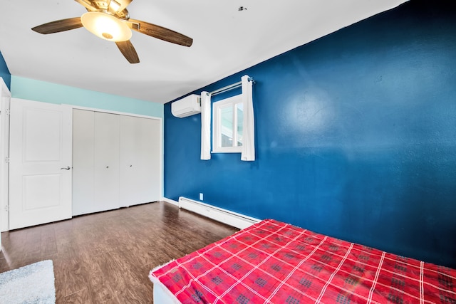 unfurnished bedroom with a baseboard heating unit, wood finished floors, a closet, a wall mounted AC, and a ceiling fan