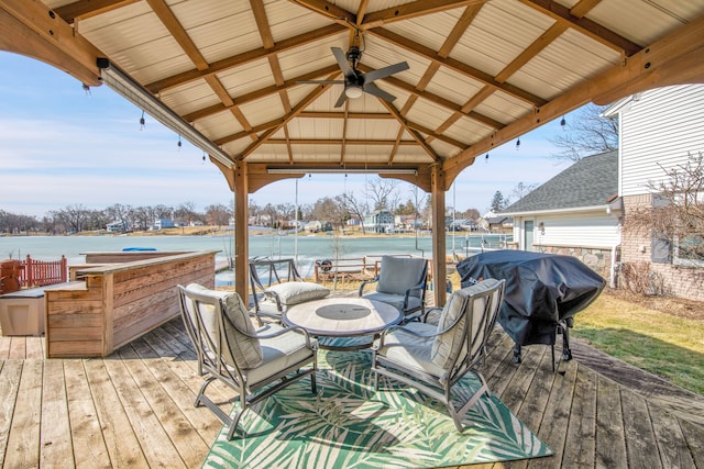 wooden terrace with a gazebo, a water view, and a grill