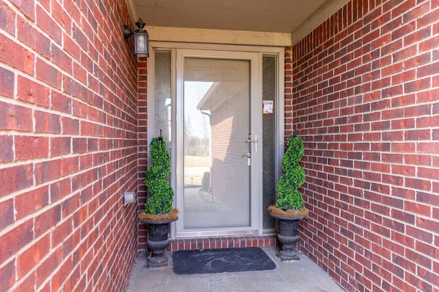 doorway to property featuring brick siding