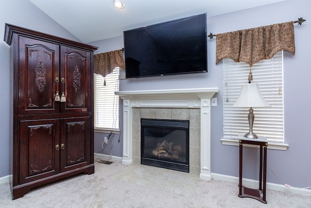 living room with a fireplace, vaulted ceiling, light colored carpet, and baseboards