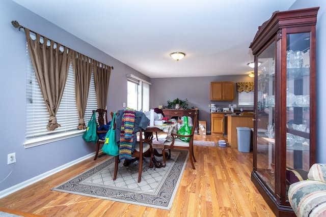 dining area featuring light wood-style flooring and baseboards