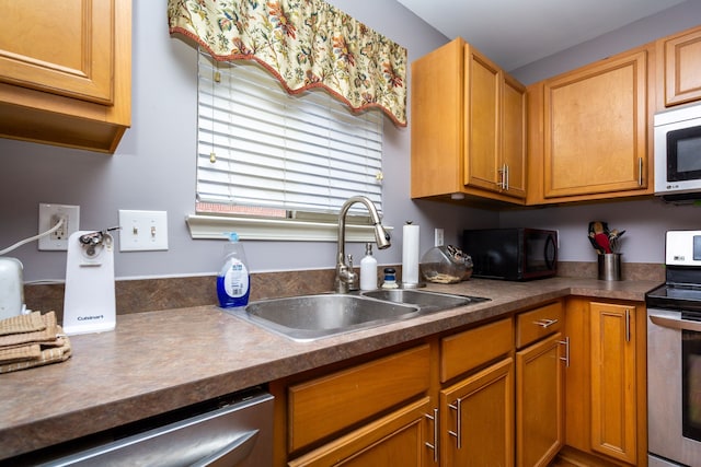 kitchen featuring a sink, dark countertops, and appliances with stainless steel finishes