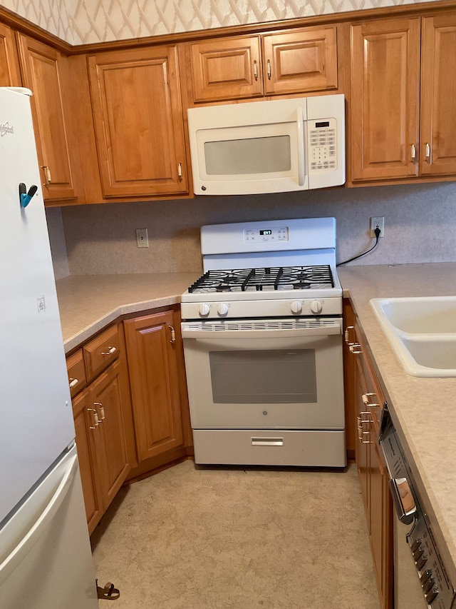 kitchen with white appliances, light floors, brown cabinets, and light countertops