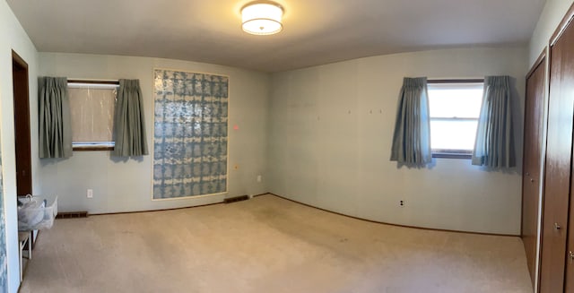 unfurnished bedroom with visible vents, baseboards, light colored carpet, and a closet