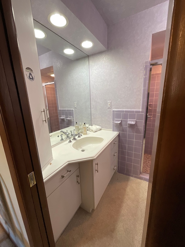 bathroom with recessed lighting, a shower stall, vanity, and a textured wall