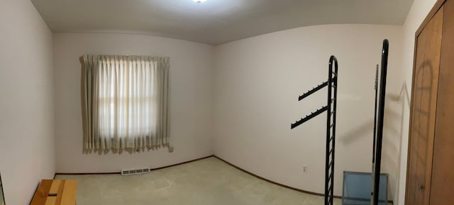 spare room with visible vents and light colored carpet