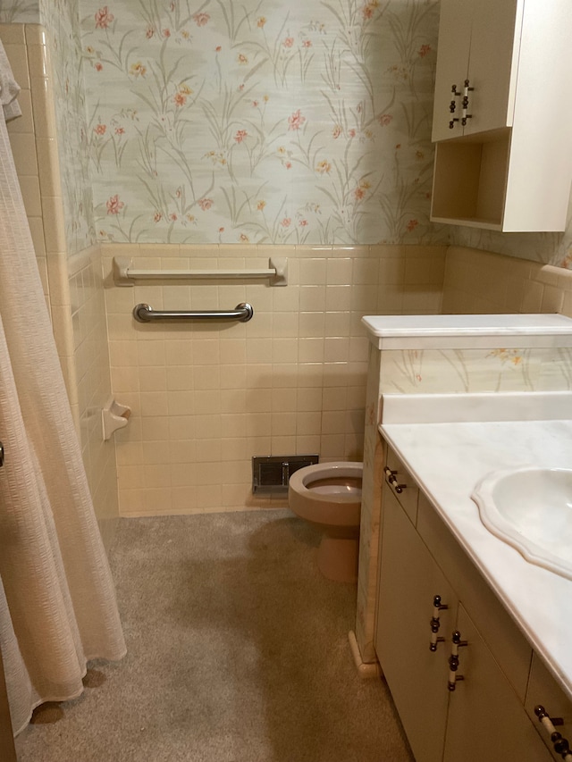 bathroom with wallpapered walls, toilet, and wainscoting