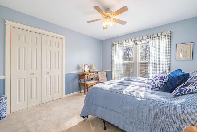 carpeted bedroom with a closet, baseboards, and ceiling fan