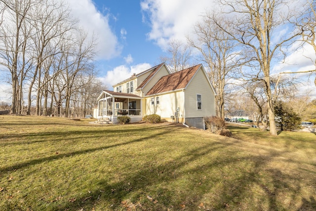 rear view of property featuring a yard and a sunroom