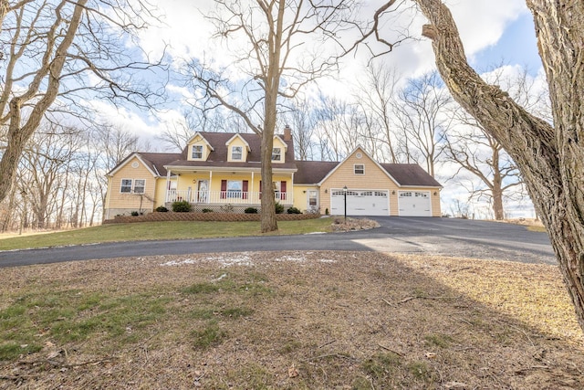 cape cod house with aphalt driveway, a porch, an attached garage, a front yard, and a chimney