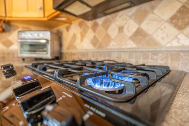 interior details featuring brown cabinetry, a toaster, and gas stove