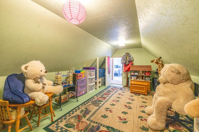 recreation room featuring a textured ceiling and vaulted ceiling