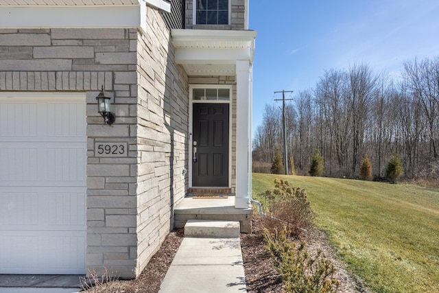 entrance to property featuring a lawn and a garage