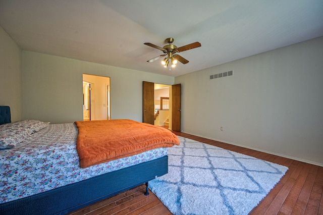 bedroom featuring hardwood / wood-style flooring, a ceiling fan, and visible vents