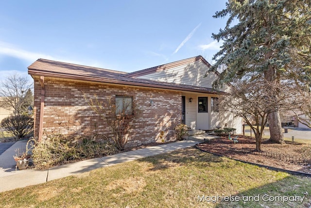 ranch-style house featuring brick siding and a front yard