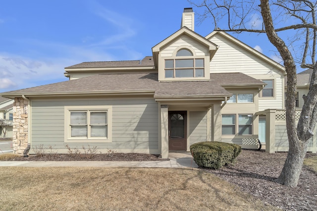 view of front of home featuring a shingled roof and a chimney