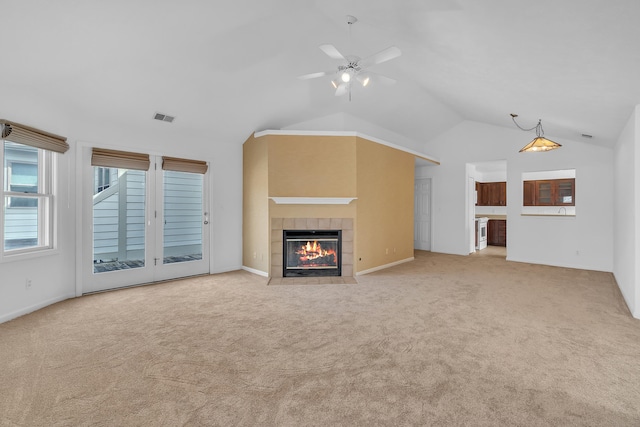 unfurnished living room featuring visible vents, ceiling fan, lofted ceiling, light carpet, and a tile fireplace