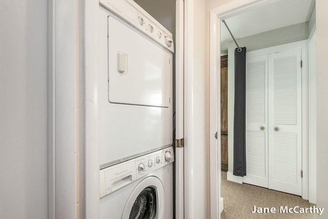 washroom featuring laundry area, carpet flooring, and stacked washer / drying machine