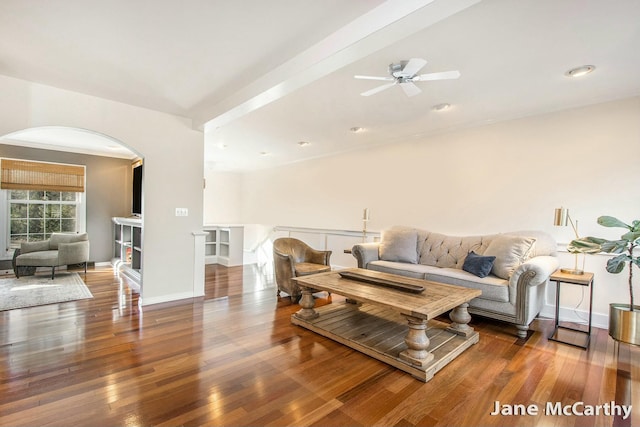 living room with a ceiling fan, hardwood / wood-style flooring, arched walkways, and baseboards