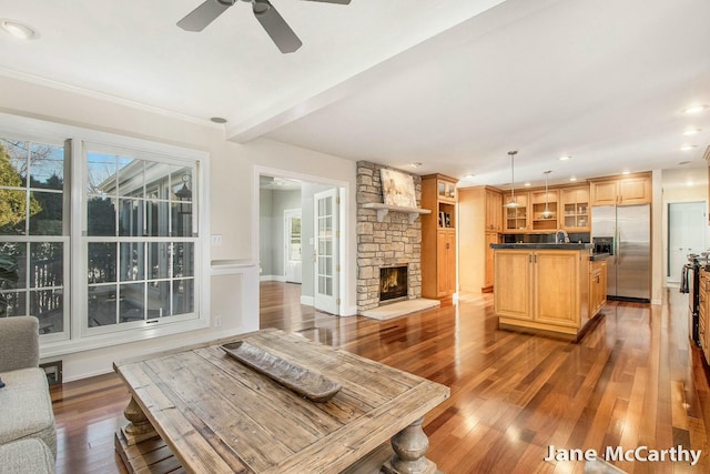 living area featuring beamed ceiling, hardwood / wood-style floors, recessed lighting, a fireplace, and ceiling fan