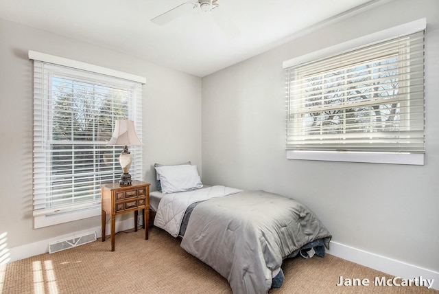 carpeted bedroom with visible vents, baseboards, and ceiling fan