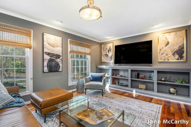 living room with a wealth of natural light, crown molding, baseboards, and wood finished floors