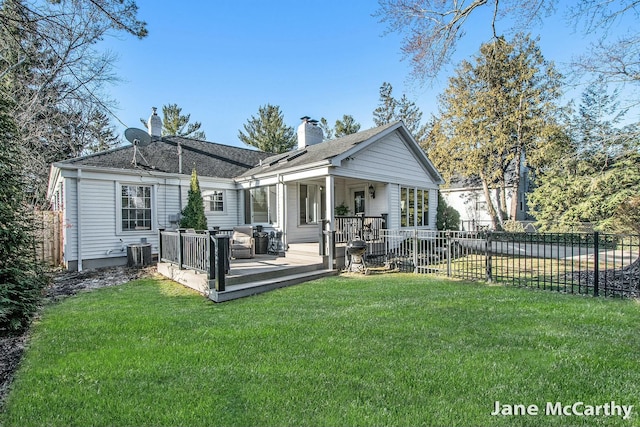 back of property featuring central AC unit, fence, a wooden deck, a yard, and a chimney