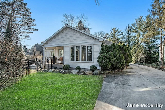 view of front of house with a front yard, fence, covered porch, and a chimney