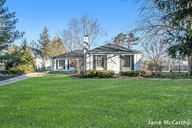 view of front of home featuring a front yard, fence, and a chimney