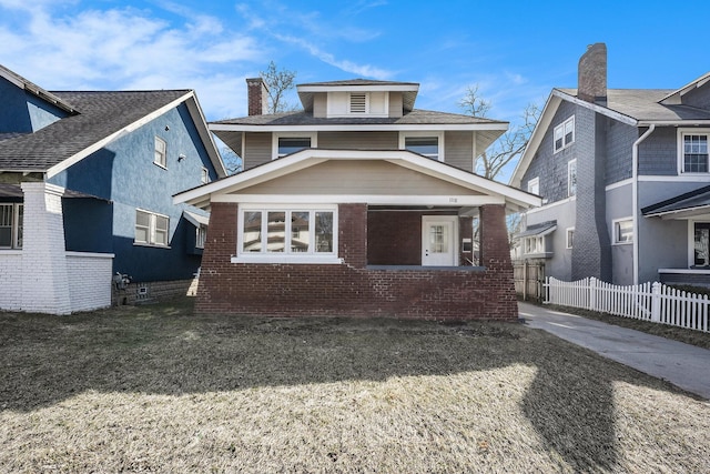 american foursquare style home featuring brick siding and fence