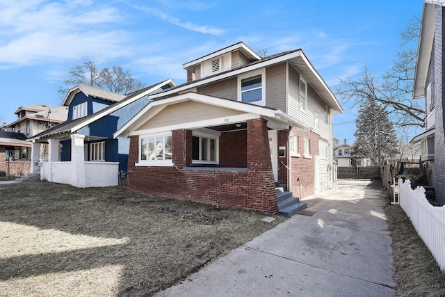 view of side of home with brick siding and fence