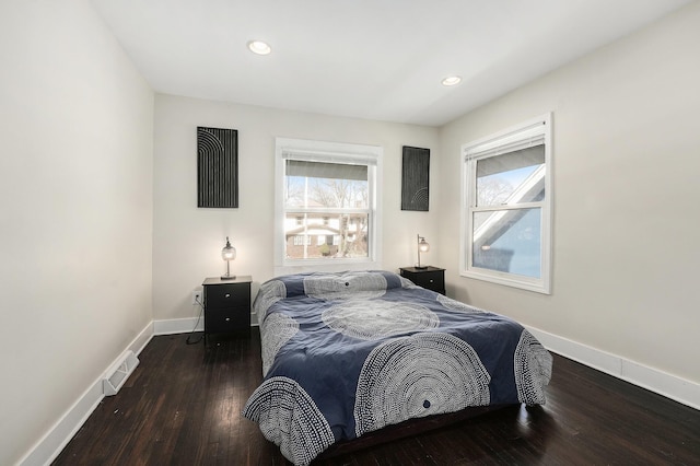 bedroom with multiple windows, baseboards, visible vents, and wood-type flooring