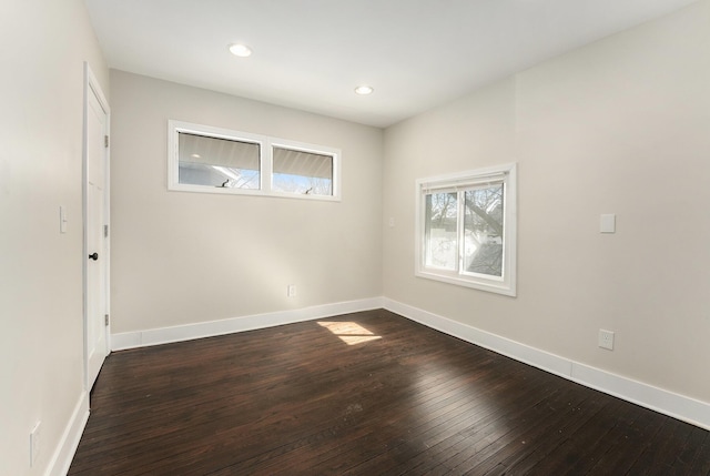 empty room featuring recessed lighting, baseboards, and dark wood finished floors