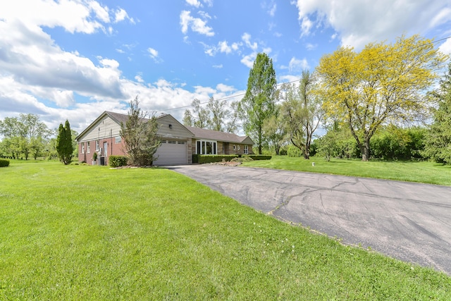 single story home with driveway, a front lawn, and a garage