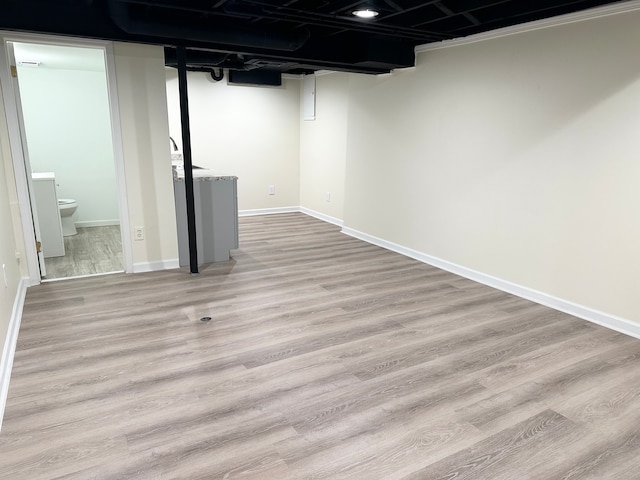 finished basement with light wood-type flooring and baseboards